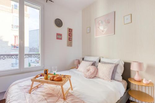 - une chambre avec un lit et une table dans l'établissement T2 petit nid rose, à Ivry-sur-Seine