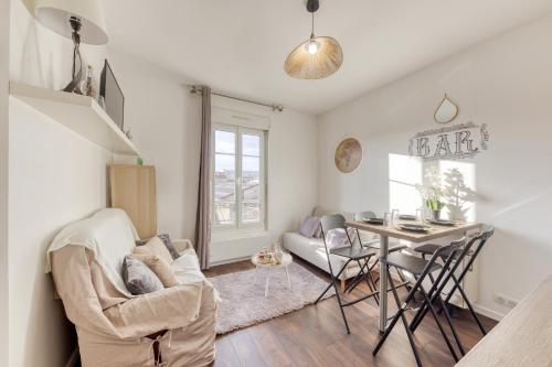 un salon avec une table et une chaise dans l'établissement T2 petit nid rose, à Ivry-sur-Seine