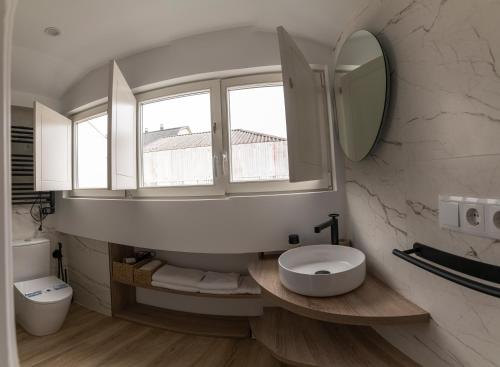 a bathroom with a white toilet and a mirror at NOARU Apartamentos Deluxe in Ares
