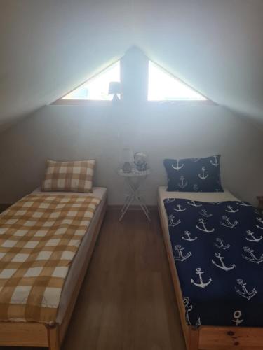 a attic bedroom with a bed and a window at Vila Šventoji in Šventoji