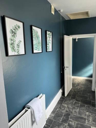 a bathroom with a blue wall with pictures on it at Pilgrims Rest in Chichester