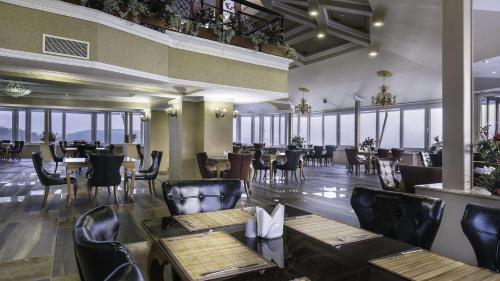 a restaurant with tables and chairs and windows at Asr-ı Ala Yalova Thermal in Gokcedere