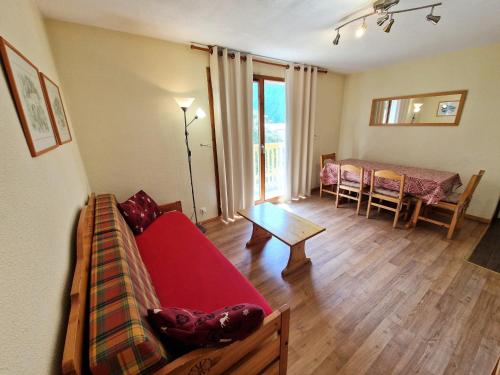 un salon avec un canapé rouge et une table dans l'établissement Charmant 2 Pièces + Cabine, Proche Pistes et Centre, 6 Couchages, Modane - FR-1-265-211, à Valfréjus