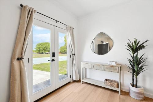 a white room with a door and a mirror at Peaceful 2BR 1BA Holiday Guest House with Hot Tub in Denton