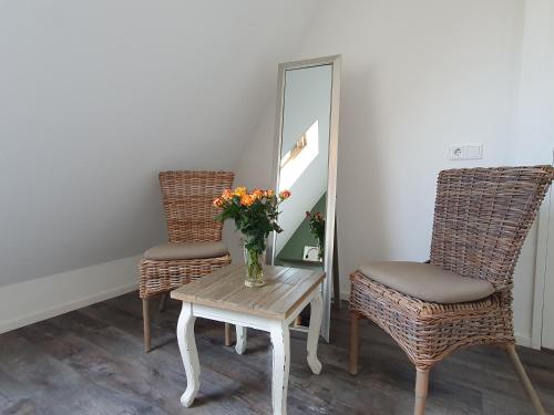 two chairs and a table with a vase of flowers at 'n Ice Day 3A in Zoutelande
