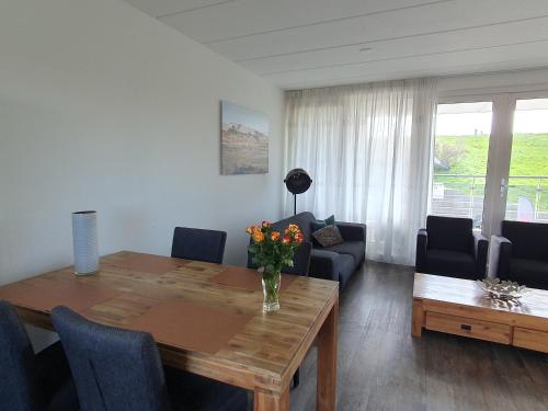 a living room with a table with a vase of flowers on it at 'n Ice Day 3A in Zoutelande