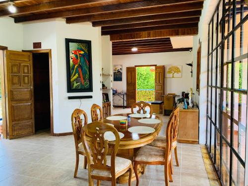 a dining room with a wooden table and chairs at Finca Hotel Calle Jardin in La Tebaida