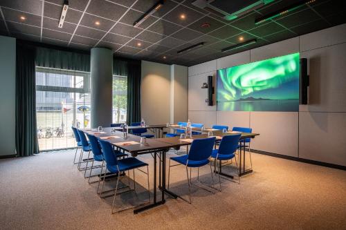 a conference room with a long table and blue chairs at Thon Hotel Rotterdam City Centre in Rotterdam