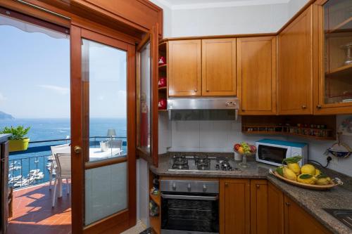 Una cocina con vista al mar desde un balcón. en Skyview Paradise House, en Amalfi