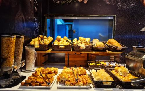 a buffet filled with different types of bread and pastries at Royal Regency Palace Hotel in Rio de Janeiro