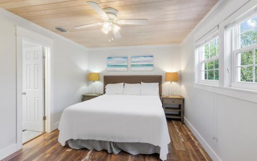 a white bedroom with a bed and two windows at Shores Fun by Oversee 30A in Seacrest
