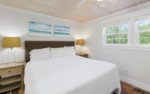 a white bedroom with a bed and two windows at Shores Fun by Oversee 30A in Seacrest