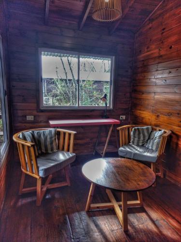 a room with two chairs and a table and a window at Cabaña Megara en Complejo Marea in Tigre