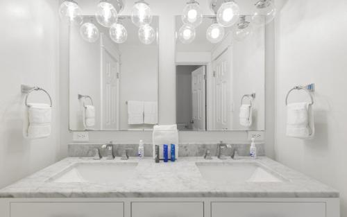 a bathroom with two sinks and a large mirror at Shores Fun by Oversee 30A in Seacrest