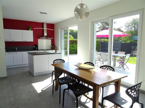 une cuisine et une salle à manger avec une table et des chaises en bois dans l'établissement Villa Rubis Varengeville, à Varengeville-sur-Mer