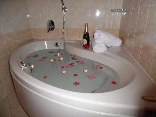 a bath tub filled with flowers and a bottle of champagne at Hotel Majestic in San Giuliano Milanese