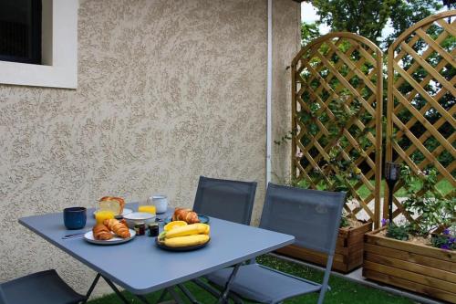 Una mesa azul con plátanos y otros alimentos encima. en Appartement Gîte des 3 Enfants, en Montluel