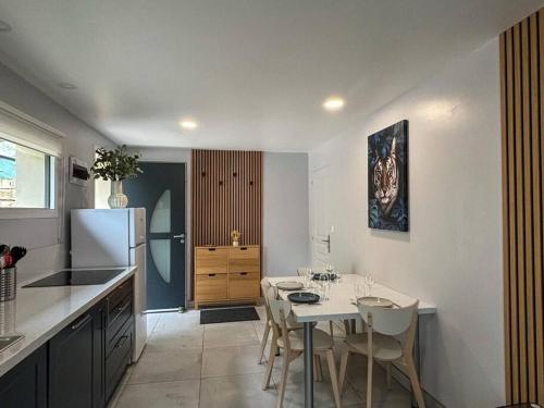 cocina con mesa blanca y nevera blanca en Appartement Gîte des 3 Enfants, en Montluel