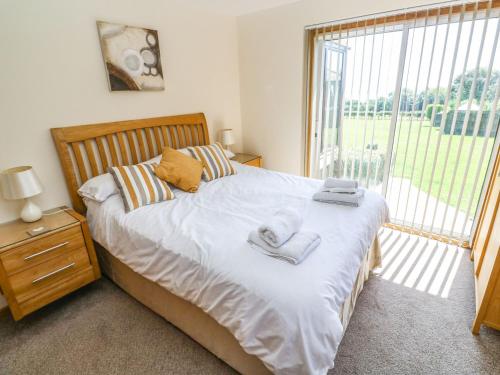 Un dormitorio con una cama y una ventana grande. en The Crows Nest, en Falmouth