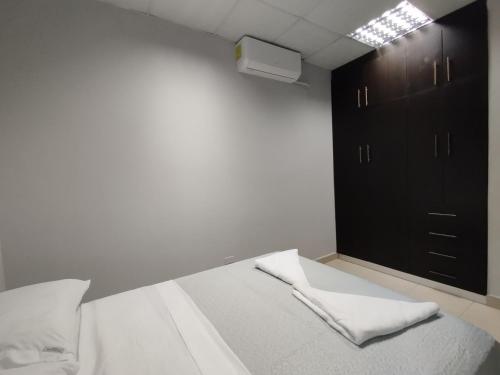 a bedroom with a bed and a black cabinet at Apartamentos Marconela in San Mateo