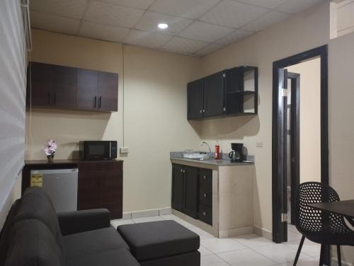a living room with a couch and a kitchen at Apartamentos Marconela in San Mateo