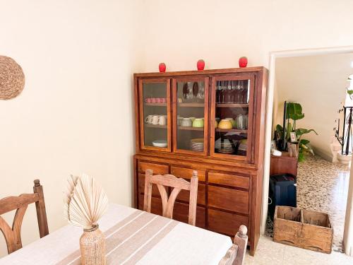a wooden cabinet in a dining room with a table at Strawberry Field in Mġarr