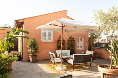 a patio with a table and an umbrella at Umiltà 36 in Rome