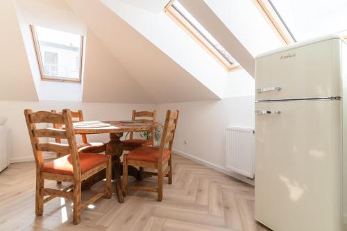 a kitchen with a table and chairs and a refrigerator at APARTAMENT KWIATKA parking klimatyzacja in Płock