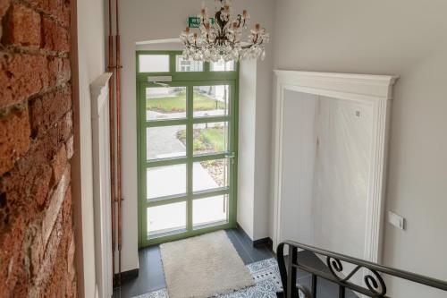 a hallway with a green door and a chandelier at APARTAMENT KWIATKA parking klimatyzacja in Płock