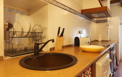 a kitchen counter with a black sink in a kitchen at Olatuenea casa rural in Sumbilla
