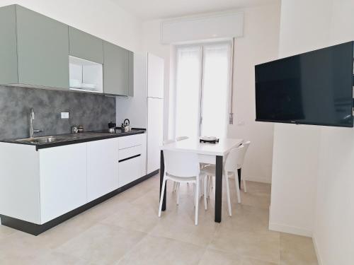 a kitchen with white cabinets and a table with chairs at Re Lear Expo in Verona