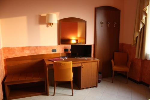 a room with a desk with a computer and a chair at Hotel Majestic in San Giuliano Milanese