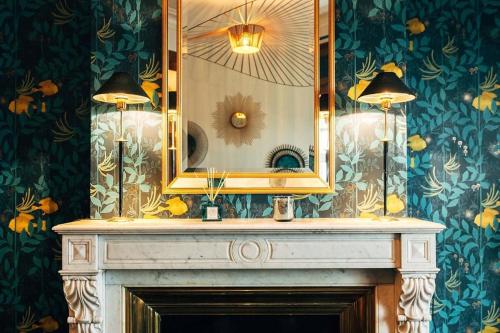 une salle de bain avec un miroir au-dessus d'une cheminée dans l'établissement Appartement 3 chambres vue sur la Garonne, à Bordeaux