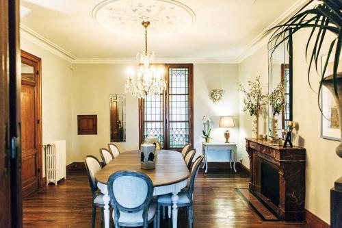 une salle à manger avec une table, des chaises et un lustre dans l'établissement Appartement 3 chambres vue sur la Garonne, à Bordeaux