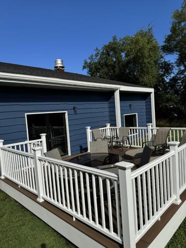 a large deck with chairs and tables on a house at AmericInn by Wyndham New Richmond in New Richmond