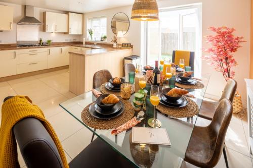 a dining room and kitchen with a glass table and chairs at Cozy Glam Patchway Garden House Sleep 9 Mid-Long Term Welcome in Bristol