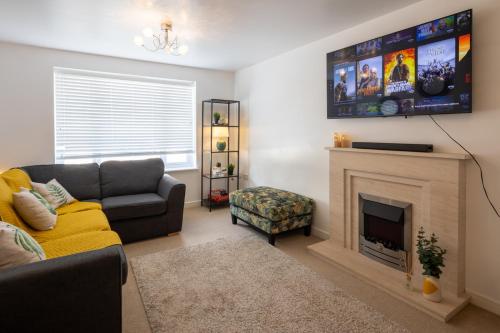 a living room with a couch and a fireplace at Cozy Glam Patchway Garden House Sleep 9 Mid-Long Term Welcome in Bristol