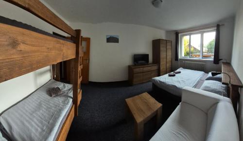 a hotel room with two beds and a couch at Pension Salma in Cerny Dul