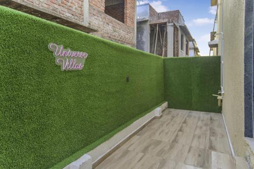a room with a green wall next to a door at 3BHK with pool - Sunset Palazzo by Universe Villas in Dhamni