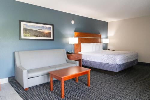 a hotel room with a bed and a couch and a table at Twin Mountain Inn & Suites in Pigeon Forge