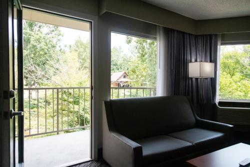 a living room with a couch and a balcony at Twin Mountain Inn & Suites in Pigeon Forge