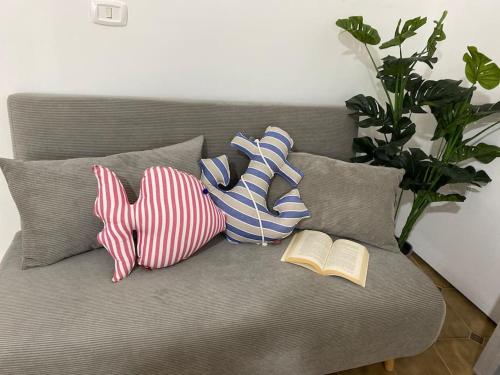 a couch with pillows and a book on it at Via Roma 55 in Lipari