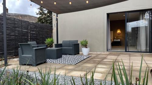 un patio con 2 sillas y una valla en Garden Suite, Hilton Accommodation, en Hilton