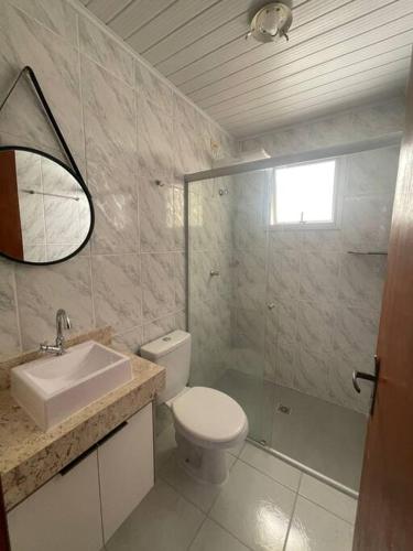 a bathroom with a toilet and a sink and a shower at Recanto das Ondas in Ubatuba