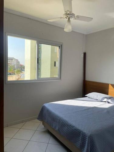 a white bedroom with a bed and a window at Recanto das Ondas in Ubatuba