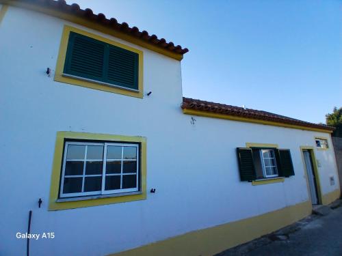 a white house with two windows and a door at Casa da Padaria in Caldas da Rainha