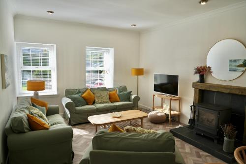 a living room with two couches and a fireplace at Country Cottage on Private Estate in Minishant