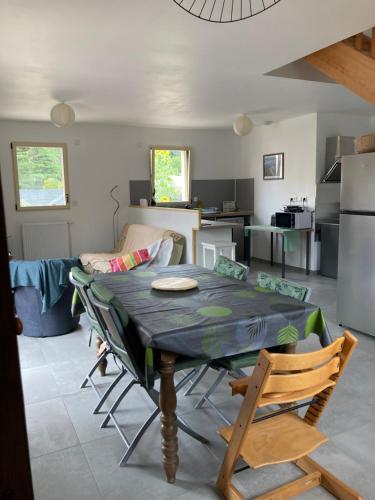 un salon avec une table et une cuisine dans l'établissement La vue de château, maison neuve en baie de somme, à Vaudricourt