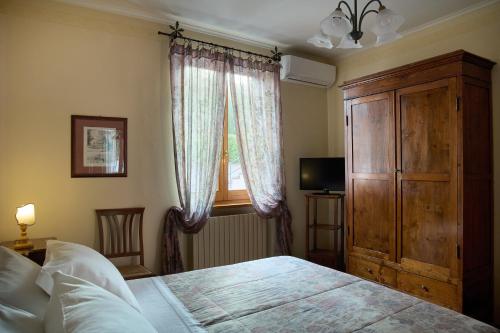 a bedroom with a bed and a dresser and a window at Albergo Villa Cristina in Spoleto