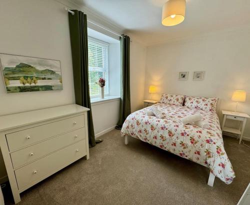 a bedroom with a bed and a dresser and a window at Country Cottage on Private Estate in Minishant